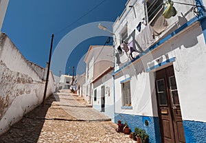 Small town in south Portugal with narrow streets and white houses under blue sky. Sunny village of Algarve region