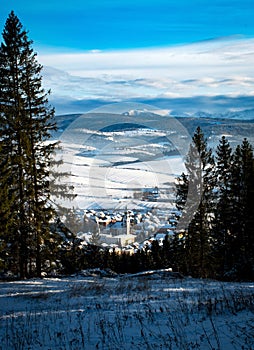 Mestečko s vežou v zimnom údolí