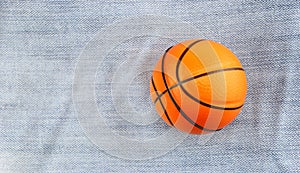 Small toy basketball on jean background