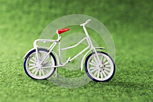 Small toy bike on green background