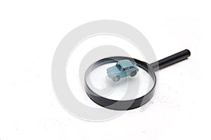 Small toy car on a magnifier white background