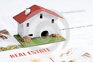 Small toy house on real estate documents.