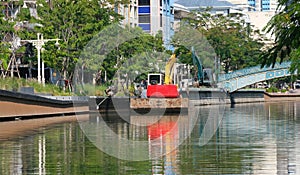 Small tracked excavator on a canal