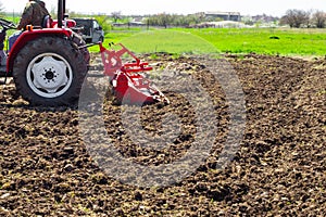 A small tractor plows the land in the garden. Agriculture and Agronomy