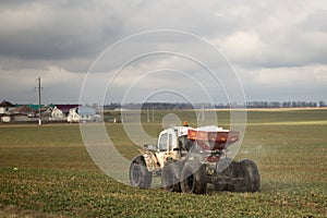 A small tractor runs in the field in early spring