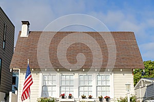 Small traditional gable house with USA flag at the front in La Jolla, California