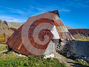 Small traditional old weathered cabin cottage hut home with metallic rusty roof found in a small mountain village made in