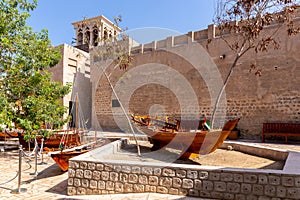 Small traditional wooden rowing boats - abras , with Al Fahidi Old Fort walls, Dubai.