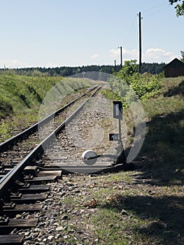 Small train station on narrow gauge. Village train station. Railroad tracks, railway traffic signs.