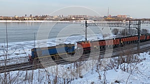 A small train travels on rails along the Angara River in Irkutsk.