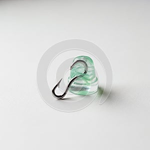 It is a shiny metallic fish hook with a sharp point and barb