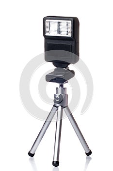 Small tripod with a flash for camera isolated over