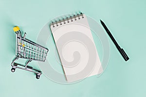 Small trolley, blank paper notepad and pen, top view.