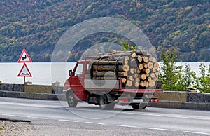 Small truck carrying wood - logs. Deforestation - concept