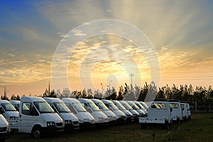 Small trucks in a parking lot under the setting sun
