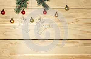 Small twigs fir tree lie on a light wooden wall background. Holiday