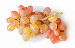 Small unch of fresh raisins grapes isolated on white. Bright saturated color of red and yellow photo