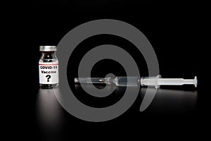 Small vaccine bottle phial with a label that reads `Covid - 19 Vaccine` and a question mark