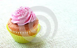 Small vanilla cupcake with strawberry icing