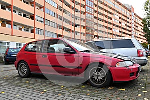 Old classic veteran dented red coupe car Honda Civic parked