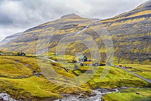 Small village,with houses with grass roofs, at the foot of the mountain. Faroe Islands. Denmark. Europe. Landscapes