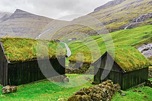 Small village,with houses with grass roofs, at the foot of the mountain. Faroe Islands. Denmark. Europe. Landscapes.