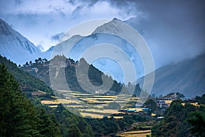 Small village on the mountain peak in fog at sunset in Nepal