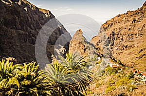 Small village on a mountain ridge. Exotic mountain landscape with palm trees. Famous mountain village of Masca on Tenerife, Canary