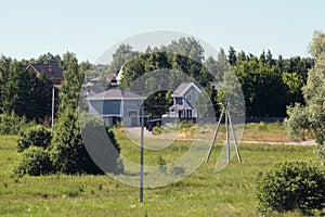 Small village with powerline poles and trees under a clear blue sky during daytime