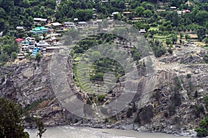 Small village reside close to falling rock formation along river at Himachal Pradesh.