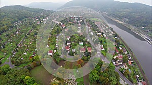 Small village town aerial shot, misty fog, river mountains air