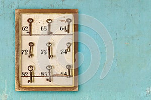 Small vintage cabinet with rusted hotel keys and room numbers