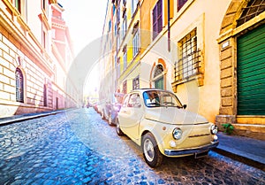 Small vintage car on beautiful street in Rome