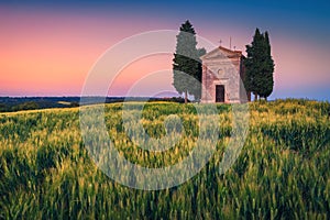 Small Vitaleta chapel and grain fields at sunset, Tuscany, Italy