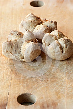 Small walnuts breads on a wooden old cutting board