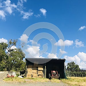 Small warehouse with tractors and straw.