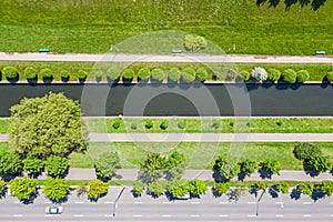 Small water canal near city road in residential area. aerial top view