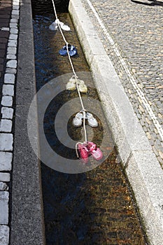 A small water-filled runnels or formalized rills called Freiburg BÃ¤chle with colorful water shoes inside.