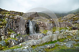 Small waterfall at the Conor Pass, one of the highest Irish mountain passes served by an asphalted road, located on the Dingle photo