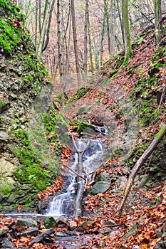 Small waterfall in creek in Turovska roklina gorge during autumn in Kremnicke vrchy mountains