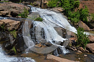Small waterfall flowing down a rockface in the forest