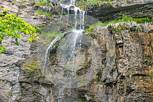 small waterfall that flows from road parapet.