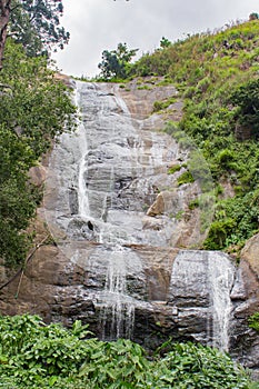 Small waterfall in green forest.