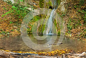 Waterfall on mountain river falling into pool