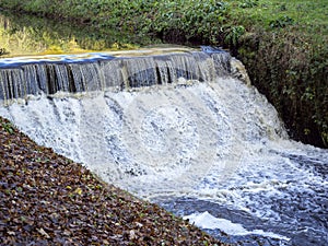 Small waterfall in a narrow fast flowing stream