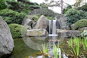 Small waterfall over rocks in a calm sea