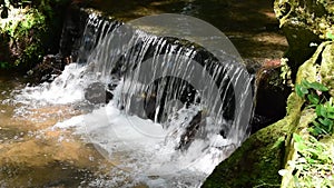 Small waterfall over rocks in the tropical rainforest