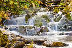 Small Waterfall in park with beautifull smooth water. Little waterfall in mountain forest with silky foaming water.