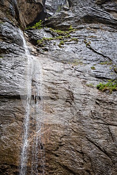 Small waterfall on rock wall background for wallpaper