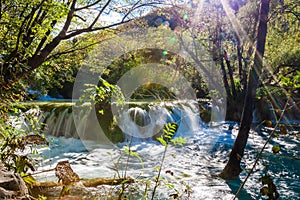 Small waterfall with sunlight rays